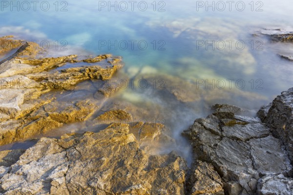 Crystal clear and turquoise water on the beach of Ustrine Bay on a sunny day on the island of Cres, long exposure, Croatia