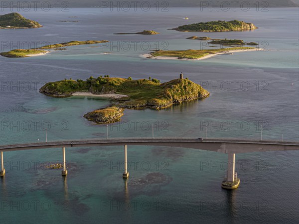 Sommaroy Bridge connecting Kvaloya Island to Sommaroy Island, warm light at sunset, aerial view, Norway