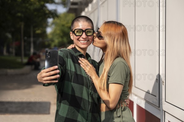A joyful Colombian lesbian couple takes a selfie outdoors, showcasing their love and happiness. This image celebrates diversity, equality, and LGBTQIA+ pride