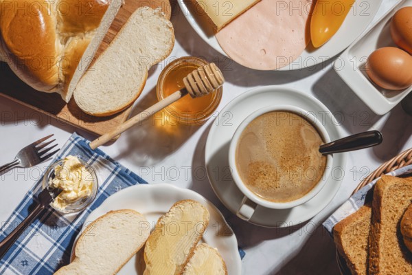 Breakfast, stollen with butter and honey, surrounded by cheese, ham, coffee, peppers and eggs