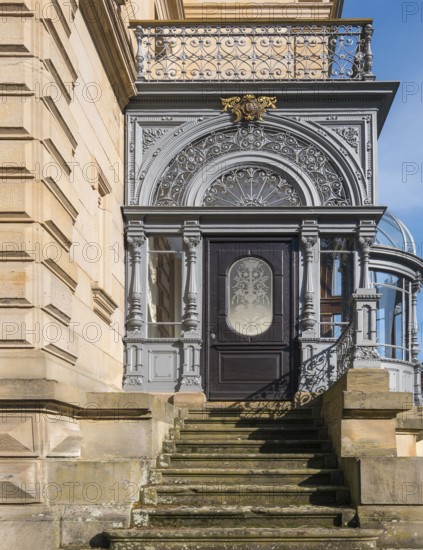 Historic door with filigree decorations and railings on a stone staircase in sunlight, Landau, Rhineland-Palatinate, Germany