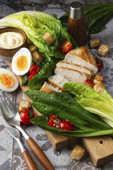 A vibrant image showing fresh Caesar salad ingredients, including romaine lettuce, grilled chicken, boiled eggs, croutons, and cherry tomatoes, neatly arranged on a rustic wooden board. Ideal for culinary themes