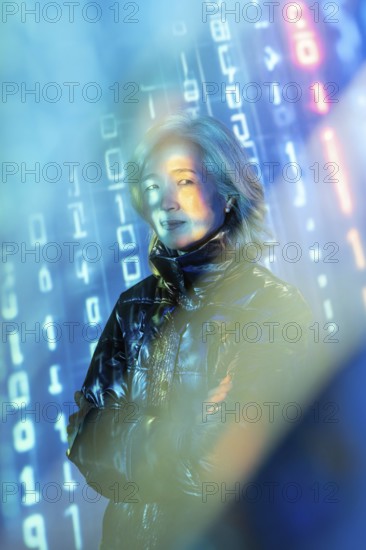 An elderly Asian woman stands confidently in the metaverse, surrounded by virtual elements and digital data streams. Her expression reflects curiosity and engagement with technology