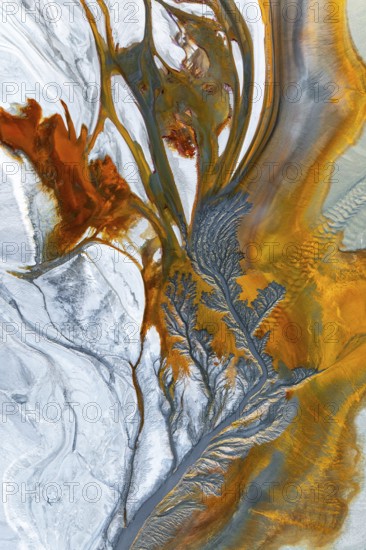 Intricate fractal patterns of vibrant mud textures create a stunning visual captured from above. Rich earthy tones blend, showcasing the complexity of natural formations