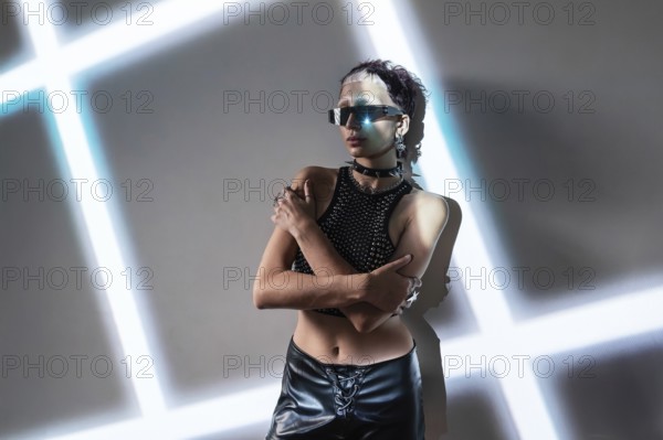 A woman embodies a cyberpunk aesthetic, wearing reflective sunglasses and a studded outfit. The futuristic setting features neon lights, highlighting an edgy, tech-inspired vibe