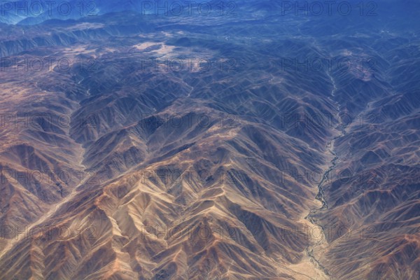 Breathtaking mountain formations in an arid desert region seen from the air, the landscape and desert near Nasca in the Andes of Peru