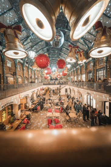 View of a decorated shopping mall with big golden bells and red balls on the ceiling, AppleMarket, London, United Kingdom