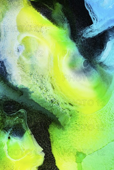 A dynamic abstract composition of swirling green, yellow, and blue inks. The vibrant textures and gradients create a sense of movement and energy in the galaxy