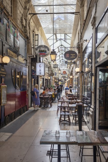 Passage with retro style, filled with food options and visitors, Paris