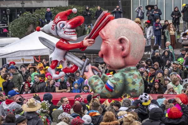 Rose Monday procession in Düsseldorf, theme car by wagon maker Jacques Tilly, Putin impales the symbolic figure of the carnival, Hoppeditz, the satire clown who fights back with the fool's joke, on the subject of court action against Tilly in Russia for his theme cars against Putin and the Ukraine war, North Rhine-Westphalia, Germany