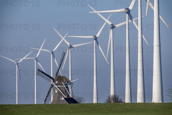 Poldermolen De Goliath windmill stands between the high-tech wind turbines in Eemshaven, historic windmill from around 1882, rebuilt and rebuilt several times, Westereems wind farm, Groningen province, Netherlands