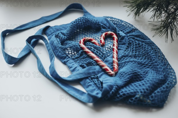 A striking image showcasing heart-shaped candy canes nestled within a vibrant blue string bag, strategically placed on a minimalist white background, foregrounding a festive theme