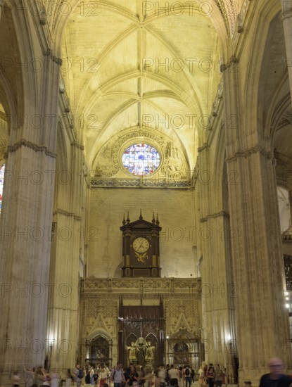 Gothic interior of a cathedral with high ceiling, stained glass window and organ, Seville, Andalusia, Spain