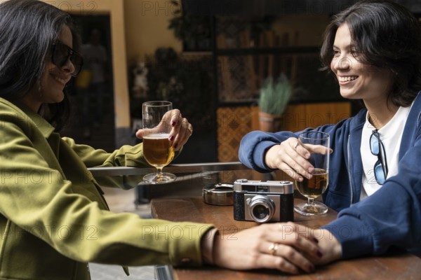 A couple enjoys each other's company over drinks at an outdoor cafe. They are relaxed and smiling, capturing a moment of leisure and happiness