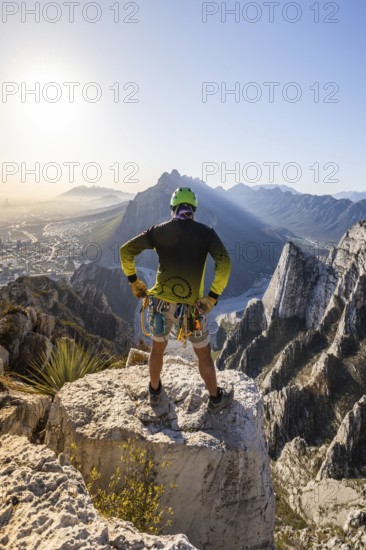 A man pauses on a rocky ledge in Eagleâ€™s Nest, Monterrey, Mexico, after a session of mountaineering and rappelling. The stunning landscape stretches behind him