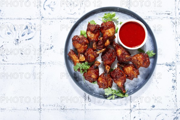 Crispy pieces of fried chicken, on a plate with sauce and herbs, in a modern kitchen environment, there are no people