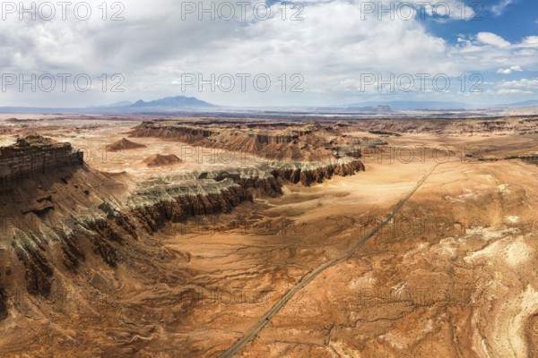 An expansive aerial shot capturing the rugged and unique terrain of Goblin Valley State Park in Utah, showcasing striking geological formations and sweeping desert vistas