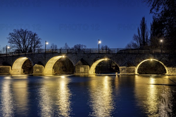 Night view of an illuminated bridge with lights reflecting in the quiet river, The Burgau Bridge in the Saale Valley near Jena in Thuringia