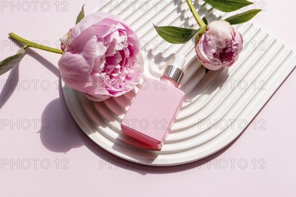 Pink cosmetic bottle alongside beautiful peonies on a stylish white corrugated plate. The floral arrangement creates a serene and elegant aesthetic, ideal for beauty-themed content