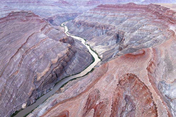 Captivating aerial photograph showcasing the sinuous Rio San Juan cutting through the rugged red landscapes of Utah, USA, revealing nature's intricate patterns and textures