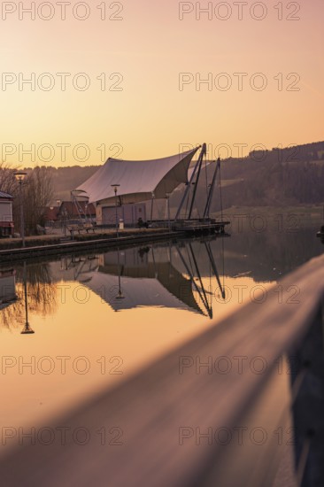 Large tent next to a pier by the lake, quiet atmosphere at dusk and reflection in the water, Großer Alpsee, Immenstadt im Allgäu, Bavaria, Germany