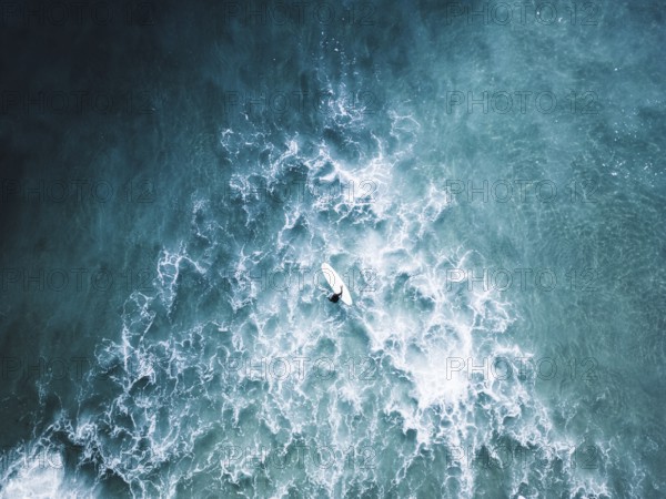 A stunning surf photo session in Portugal captures surfers navigating vibrant blue waves. The scene evokes the thrill of the ocean and the spirit of adventure at sea