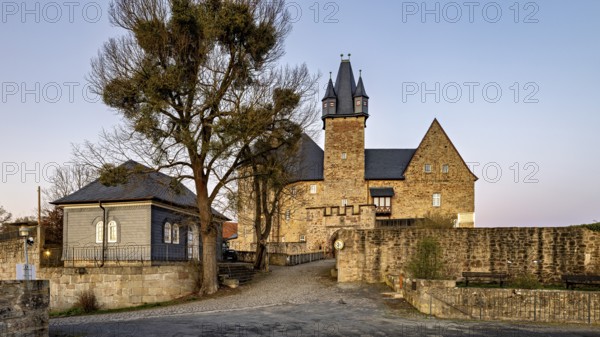Evening view of a castle with courtyard, illuminated by warm light in front of sunset, Spangenberg Castle