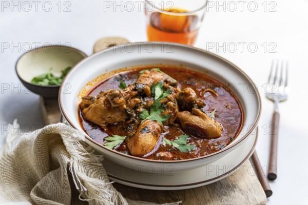 A flavorful bowl of traditional Georgian chakhokhbili chicken stew made with tender chicken pieces in a rich tomato sauce, seasoned with paprika and fresh coriander