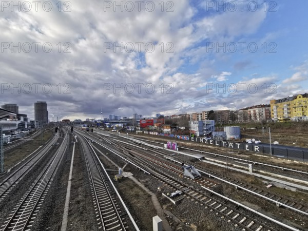 Panorma of urban rail infrastructure under a cloudy sky in summer with city in the background, Berlin