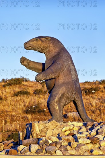 Large sloth statue on a rocky ground in a dry landscape with a clear sky, The statue of the giant sloth near Puerto Natales in Patagonia Chile