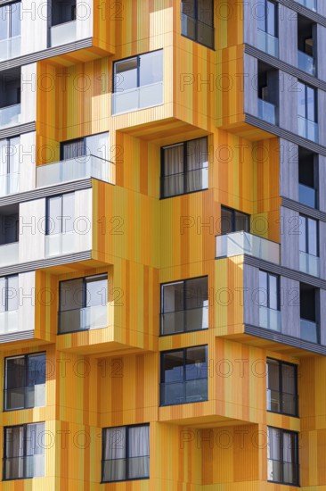 A cutting-edge design in suburban modern architecture, highlighting a dynamic combination of materials such as glass, concrete, and metal. Vibrant orange panels interspersed with grey provide a fresh take on urban building exteriors
