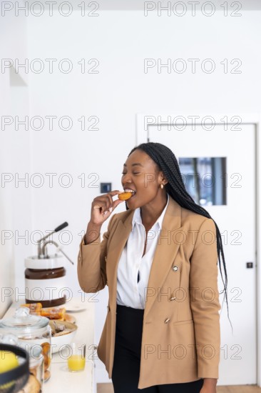 Businesswoman enjoying a delicious pastry while savoring the hotel breakfast buffet during a corporate trip, feeling relaxed and confident
