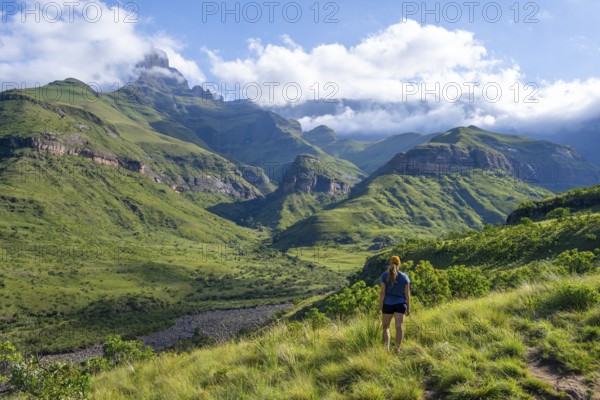Young female hiker between mountains, Drakensberg National Park, KwaZulu Natal, South Africa