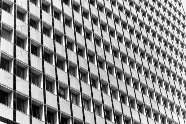 Black and white image of a building facade with repetitive square windows in Sidney, Australia. Captures the geometric symmetry and architectural design, highlighting urban aesthetic