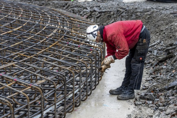 Assembly of reinforcing steel for the reinforced concrete foundation of a wind turbine, a mesh of rebar and reinforcing steel mesh, connecting the steel elements with binding wire, twisting with tongs, over 100 tons of reinforcing steel were used, the wind turbine will have a hub height of 160 meters, part of a new wind farm in Sauerland, near Balve, North Rhine-Westphalia, Germany