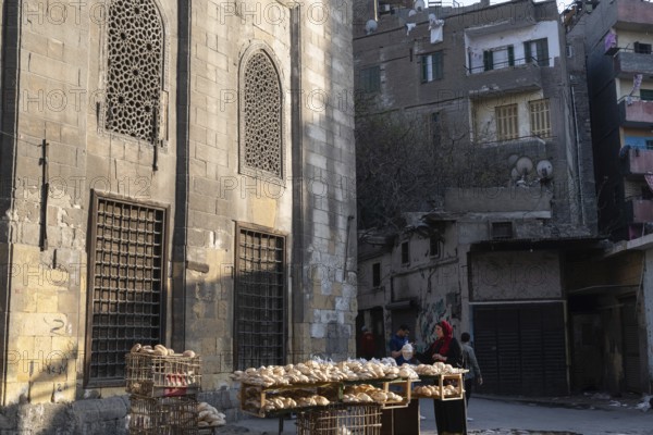 Cairo, Egypt. April 15th 2025. An Egyptian women sells freshly baked Baladi flat bread from a street stall in the crowded Sayeda Zeinab district of Cairo, the Egyptian capital, Egypt