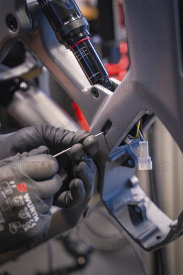 Cables being laid in a bicycle frame, hands with gloves working on it, Waldbike Manufaktur, bicycle workshop, Calw, district of Calw, Black Forest, Germany