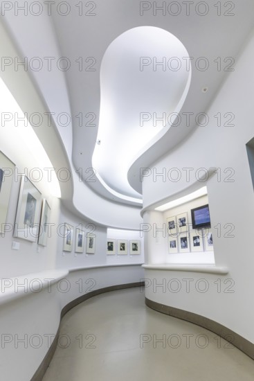 Bright, minimalist exhibition space with undulating white walls and artworks on the walls, Berlin, German cinematography, Germany