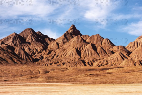 This image showcases the unforgiving terrain of Devil's Desert in Salta, Argentina. The sharp, rugged mountains stand prominently under a clear blue sky, highlighting the arid beauty of this distinctive desert landscape