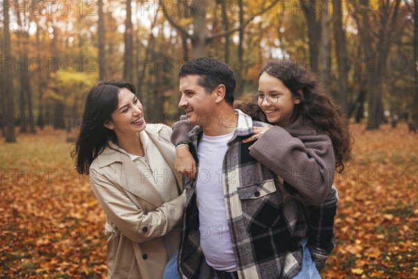 A cheerful family walks in an autumn forest, surrounded by vibrant foliage. They enjoy the crisp air and warm colors, embracing the beauty of the season together