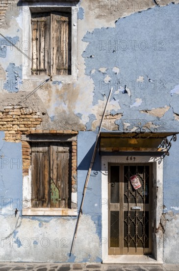 Dilapidated blue house facade with entrance door and windows, colourful houses on the island of Burano, Venice, Veneto, Italy