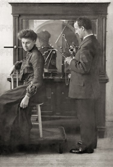 A patient being treated by Proffessor Wilhelm Conrad Röntgen with a direct spark treatment, an early electric medical Electro-Therapeutics