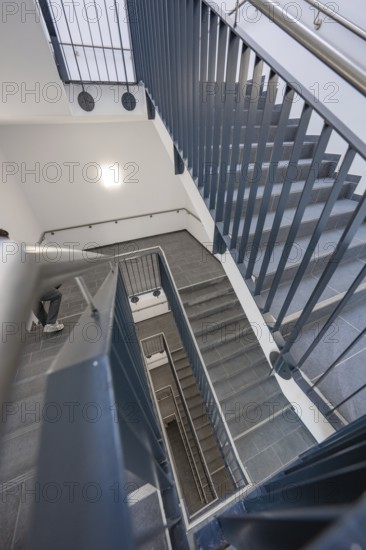 View from above of a modern staircase with metal railing that connects several floors, new Calw hospital, Germany