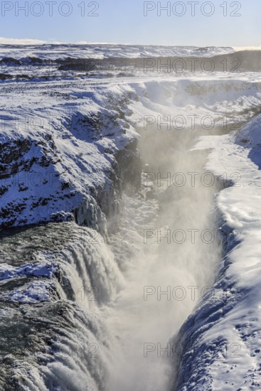 Large waterfall in a gorge in the snow, winter, sunny, backlight, spray, Gullfoss, Golden Circle, Southwest Iceland, Iceland