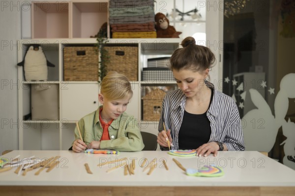 A teacher guides a child through a fun art lesson. The room is filled with colorful supplies, encouraging exploration and creativity in a nurturing environment
