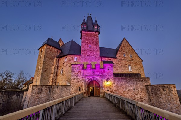 Atmospherically illuminated castle at night, access via a bridge, Spangenberg Castle