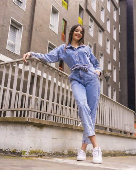Young caucasian girl with a monkey cowboy and a black bag. Enjoying the city on vacation, lifestyle of a young girl on walking a green house, towned on a railing