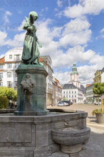 Pigeon girl on the Schlegel fountain in front of the town hall, in the background the Nicolai Church and the Amtshaus, Döbeln, Saxony, Germany