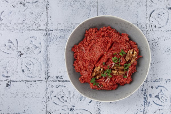 Mahammara red pepper sauce, with walnuts, and sprigs of fresh microgreens, homemade, no people