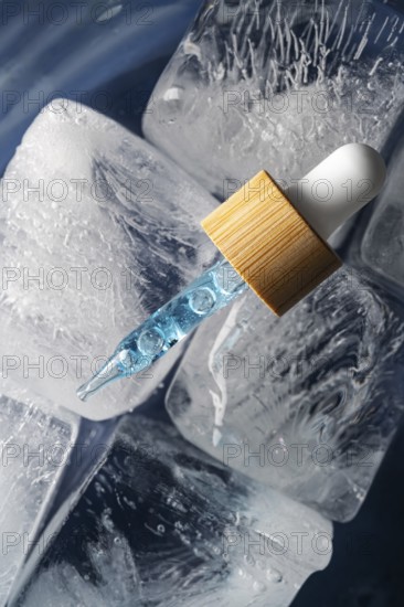 A rejuvenating face care serum or oil for men, presented in a stylish dropper bottle encased in ice cubes, designed to highlight its cooling effects on the skin